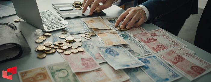 سکه‌های طلا و اسکناس‌های دلار و یورو روی میز صرافی ساری